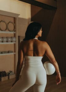 Pilates instructor standing with exercise ball in hand inside Solace Studio, photographed for personal branding and wellness photography.