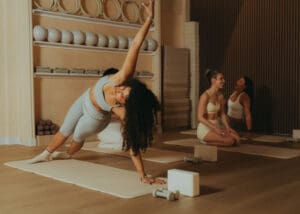 Group Pilates class performing synchronized core exercises on mats, photographed for fitness brand photography and studio marketing content.