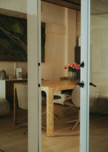 Solace Studio lounge and meeting space with wood table, chairs, and warm natural light photographed for Orlando wellness branding photography.