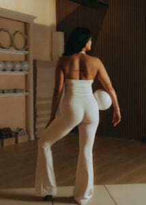 Pilates instructor standing with exercise ball in hand inside Solace Studio, photographed for personal branding and wellness photography.