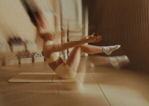 Pilates instructor performing core exercise on mat with intentional motion blur, photographed at Solace Studio in Orlando.