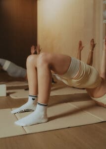 Group Pilates class performing synchronized core exercises on mats, photographed for fitness brand photography and studio marketing content.