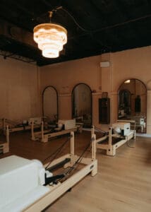 Pilates reformers arranged inside Solace Studio in Orlando with warm lighting and arched mirrors for wellness branding photography.