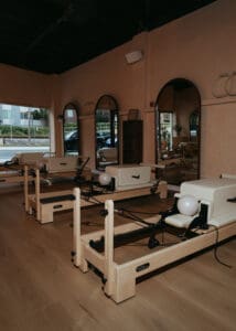 Pilates reformers lined up inside neutral-toned wellness studio photographed for Solace Studio branding photography in Orlando.