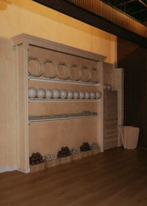 Close-up interior photo of modern Pilates studio with reformers, neutral tones, and wood panel walls.