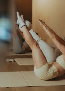 Group Pilates class performing synchronized core exercises on mats, photographed for fitness brand photography and studio marketing content.